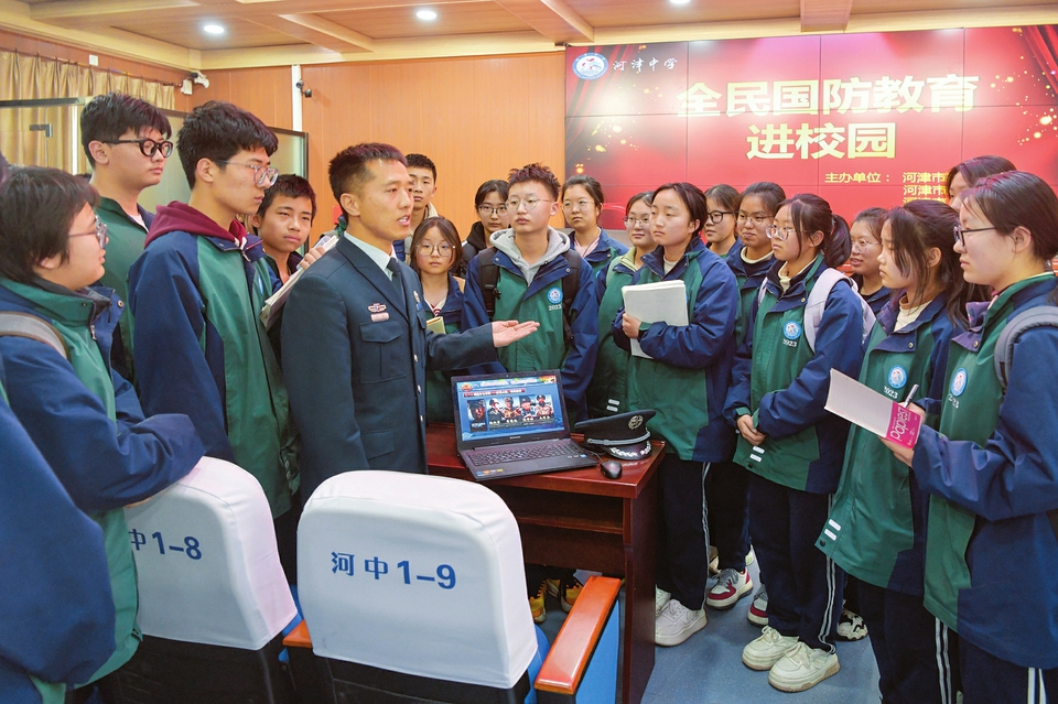 3月13日,河津市人武部工作人员正给河津中学学生讲解国防知识.