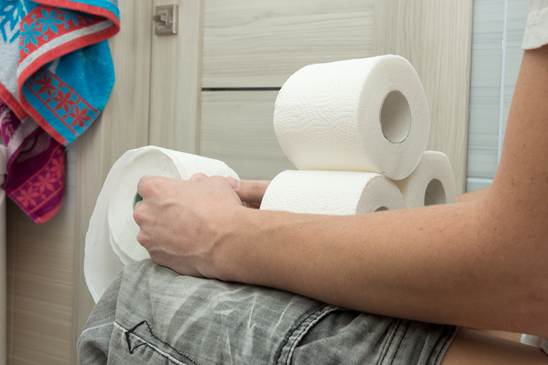 摄图网_307053995_成人男子坐在马桶上手持几卷卫生纸(企业商用)